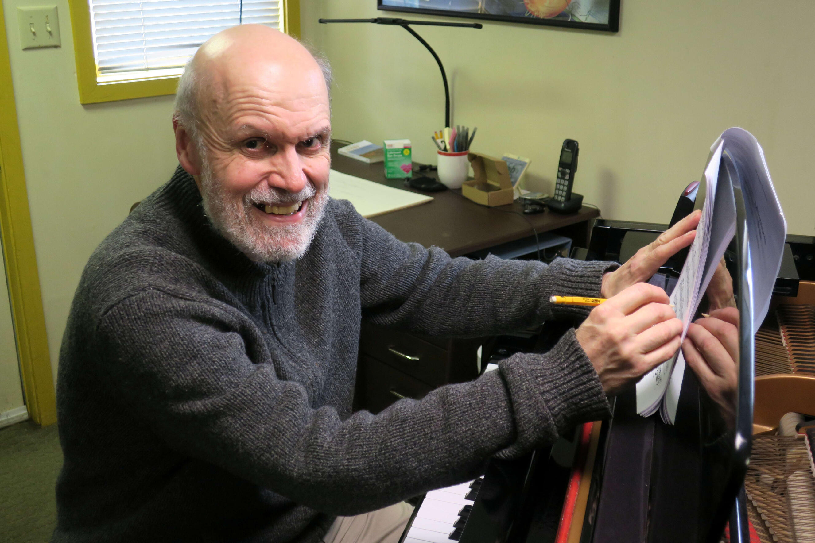 Stephen Demers, composer, working at the piano in his home studio.